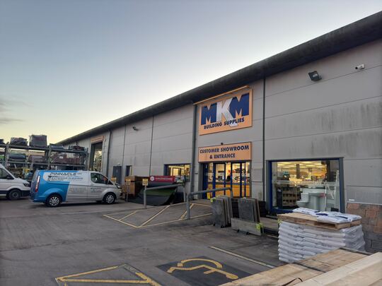 Builders' merchant store front and yard after cleaning, with the Pinnacle NW van parked