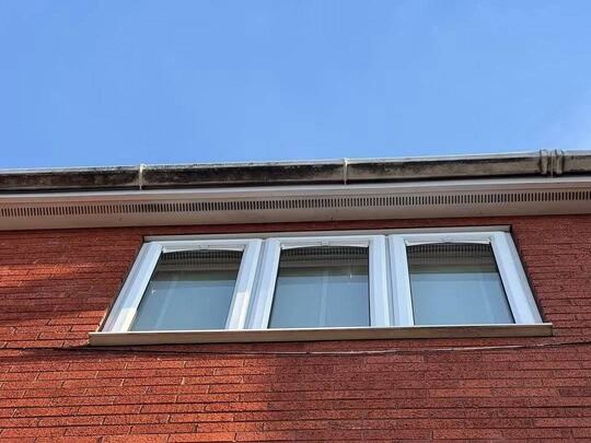 Before: white uPVC fascia and soffit above a window