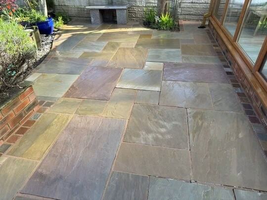 After: sandstone patio by a conservatory