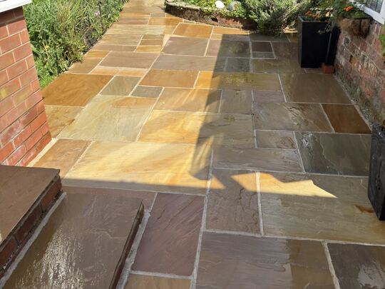 After: natural stone patio and path running down a cottage garden