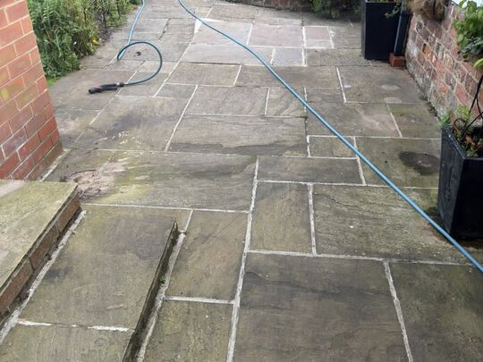 Before: natural stone patio and path running down a cottage garden