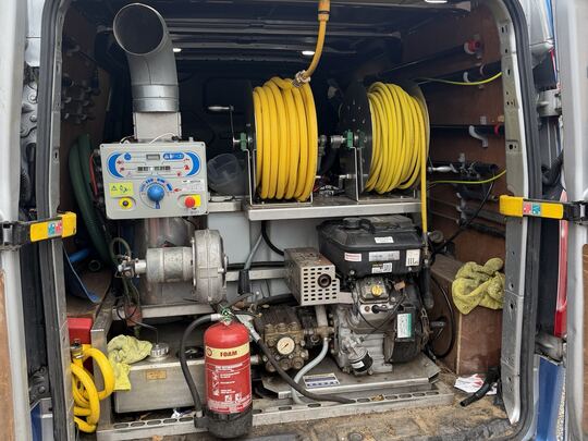 Rear doors of the Pinnacle NW van open, showing the built-in pressure washer, hot water boiler, engine and two yellow hose reels